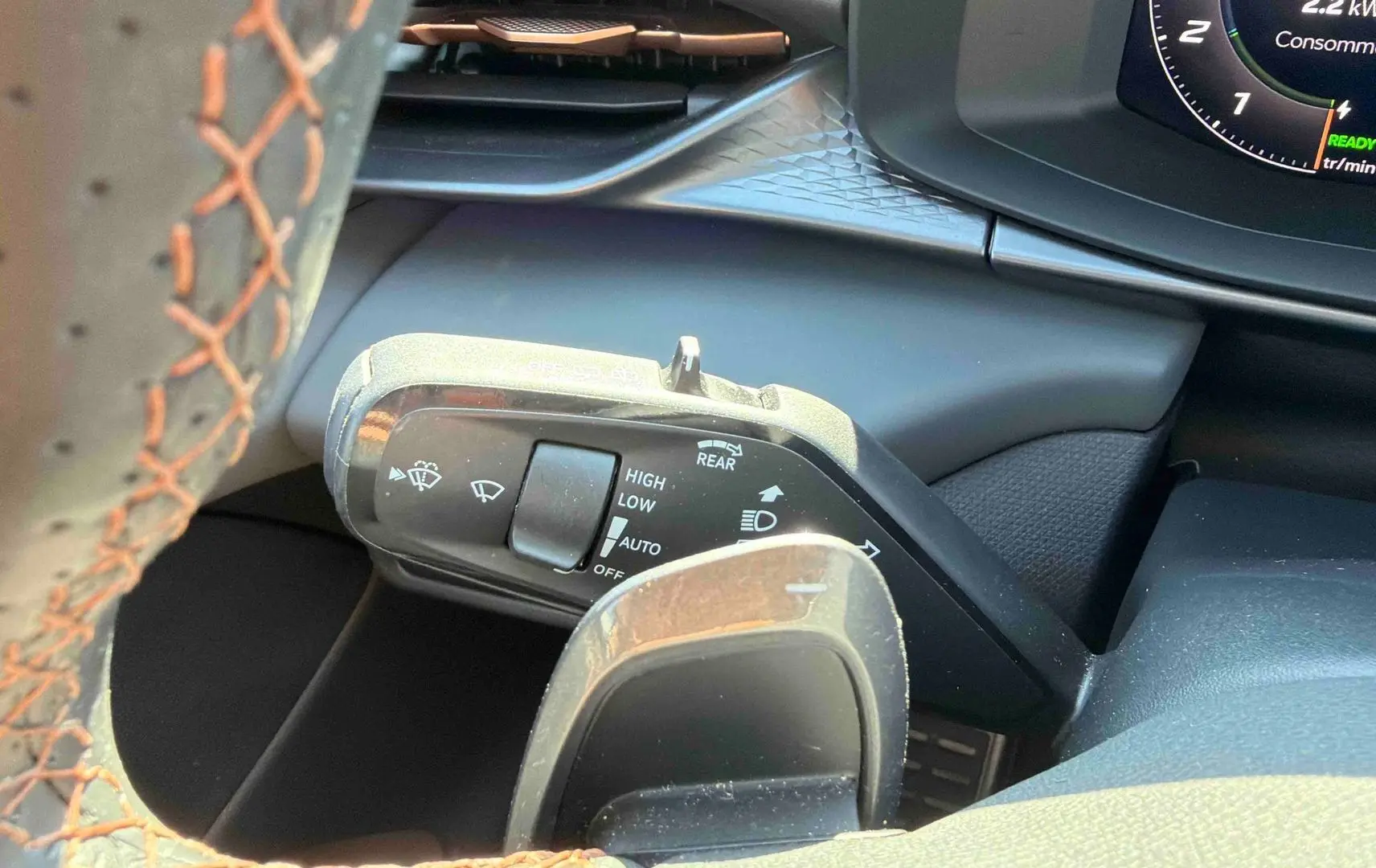 Gros plan sur la manette de commande des essuie-glaces à gauche du volant cuir perforé du CUPRA Terramar gris.