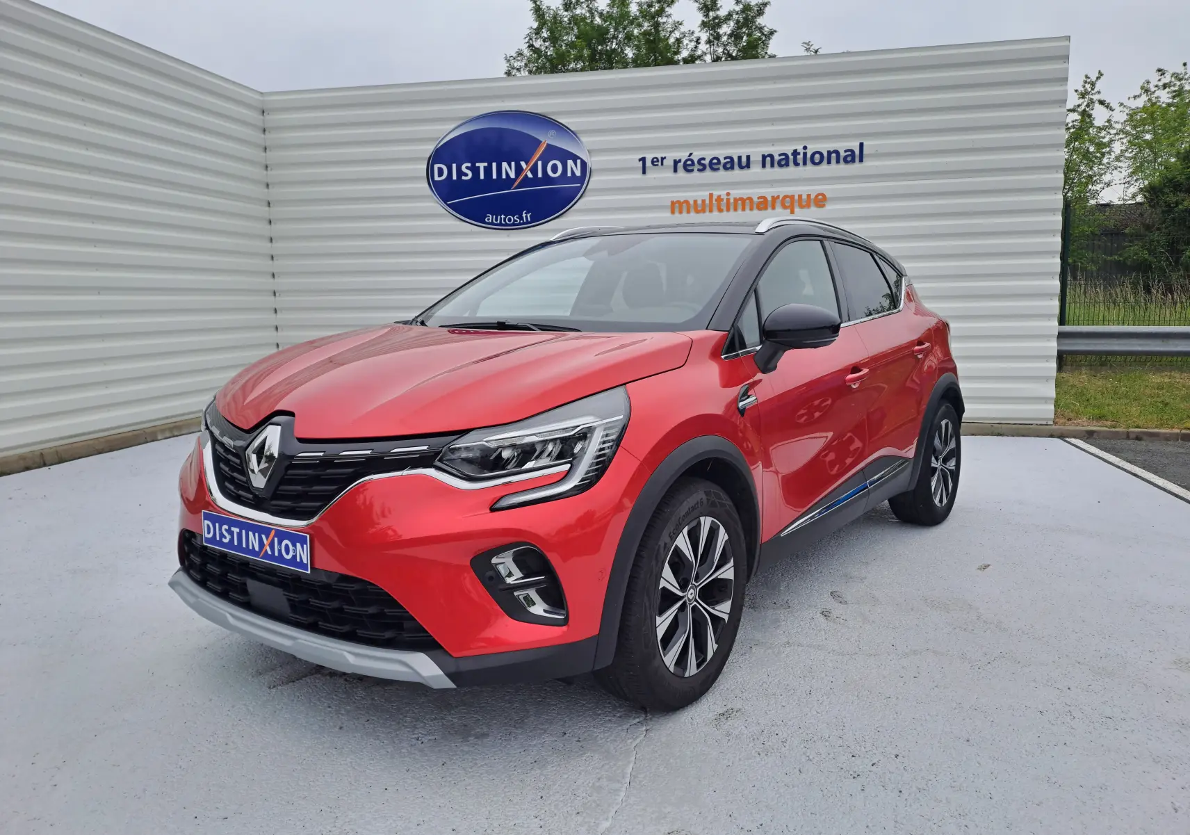 Renault Captur TCE 90CH TECHNO rouge flamme métal en 3/4 avant droit avec toit noir et jantes alliage bicolores.