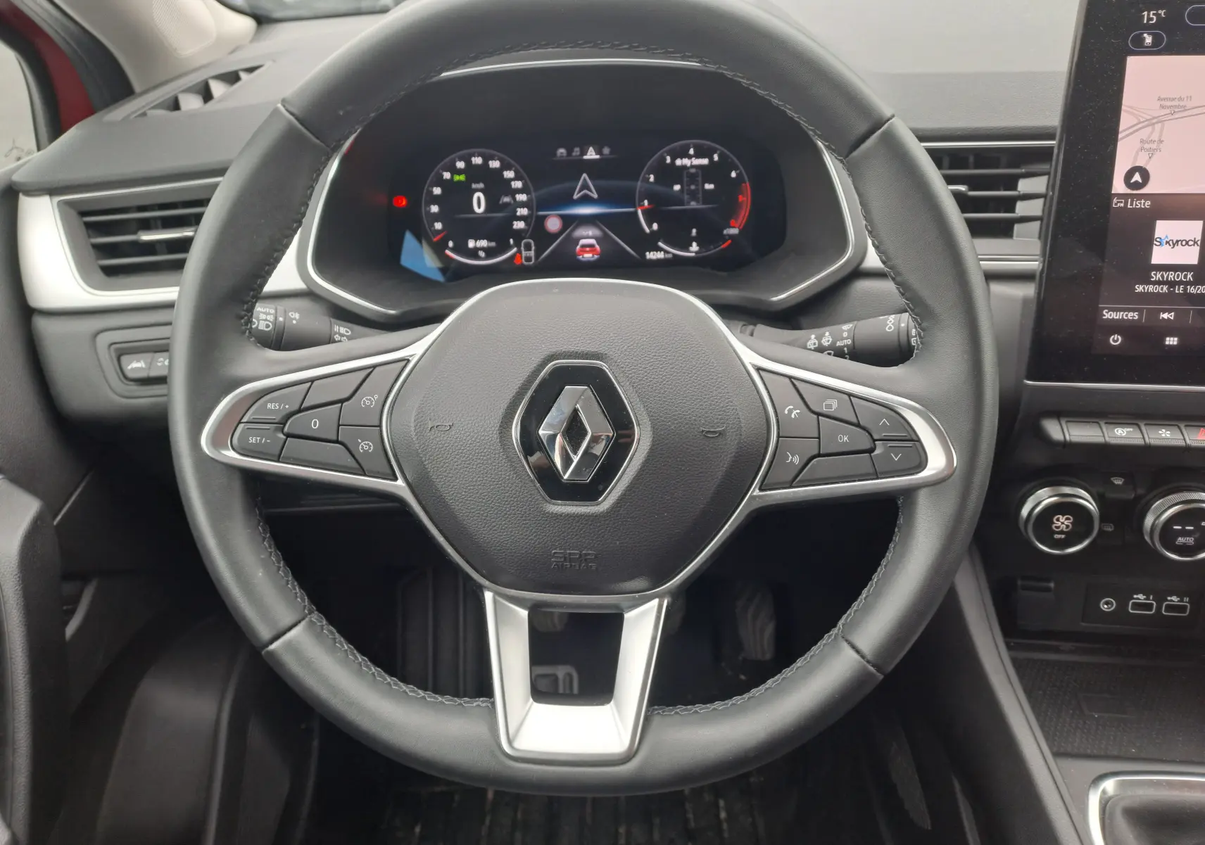 Vue rapprochée du volant cuir noir du Renault Captur 2024 TCE 90CH TECHNO avec tableau de bord numérique et écran tactile.