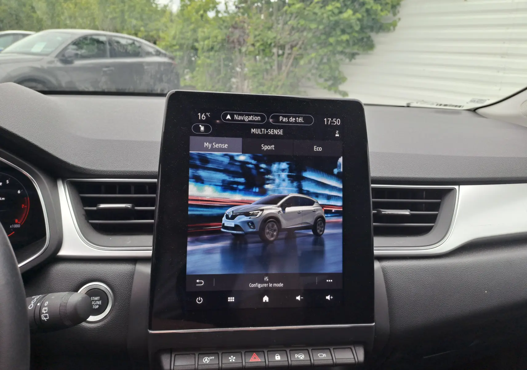 Écran central affichant une Renault Captur rouge flamme métal en mouvement, vue 3/4 avant dynamique.