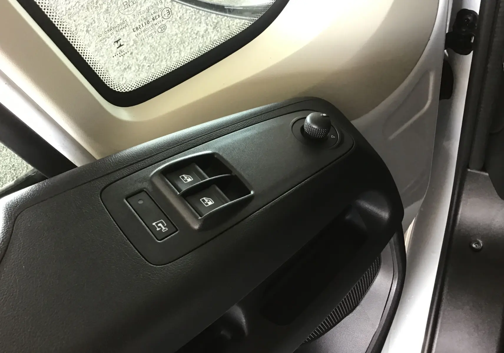 Détail des commandes de lève-vitres et réglage des rétroviseurs côté gauche du Peugeot Boxer Fourgon blanc 2025.