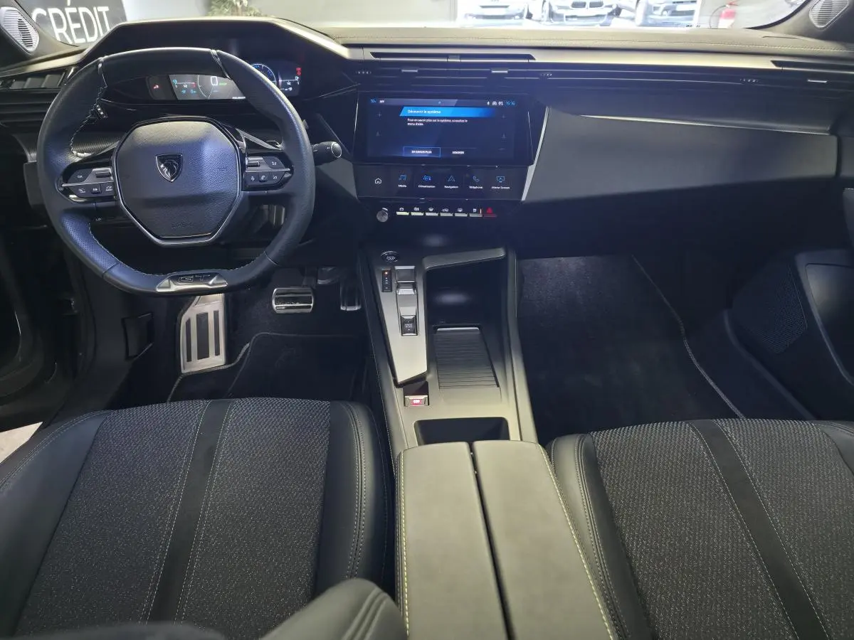 Vue intérieure avant de la Peugeot 408 GT 2025, tableau de bord moderne avec écran tactile 10 pouces et volant compact GT.
