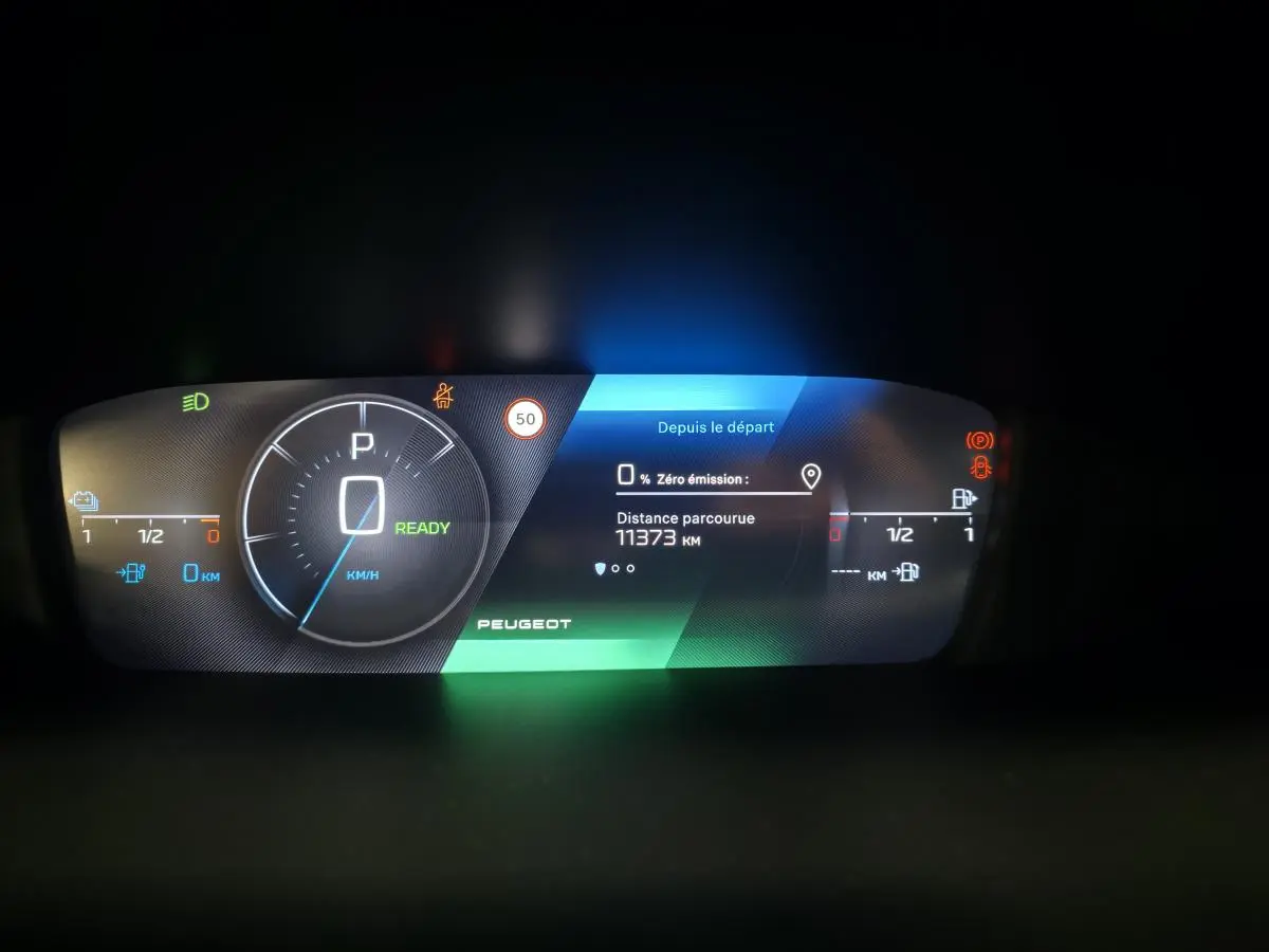 Tableau de bord numérique Peugeot 408 2025 affichant vitesse, autonomie et distance parcourue, éclairage multicolore.
