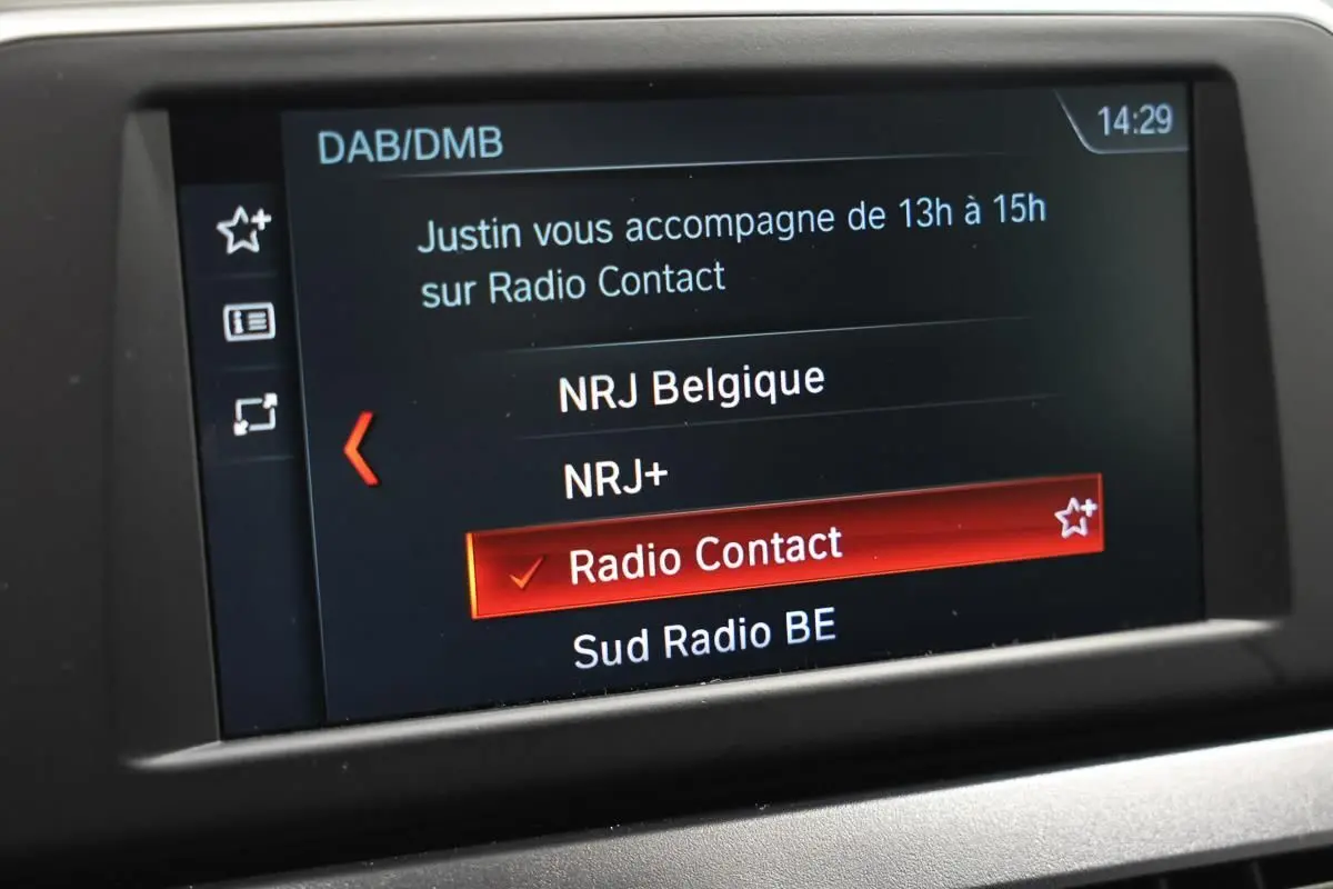 Écran central de la BMW Série 2 Active Tourer 216d blanc affichant la sélection de la radio "Radio Contact" en mode DAB/DMB.