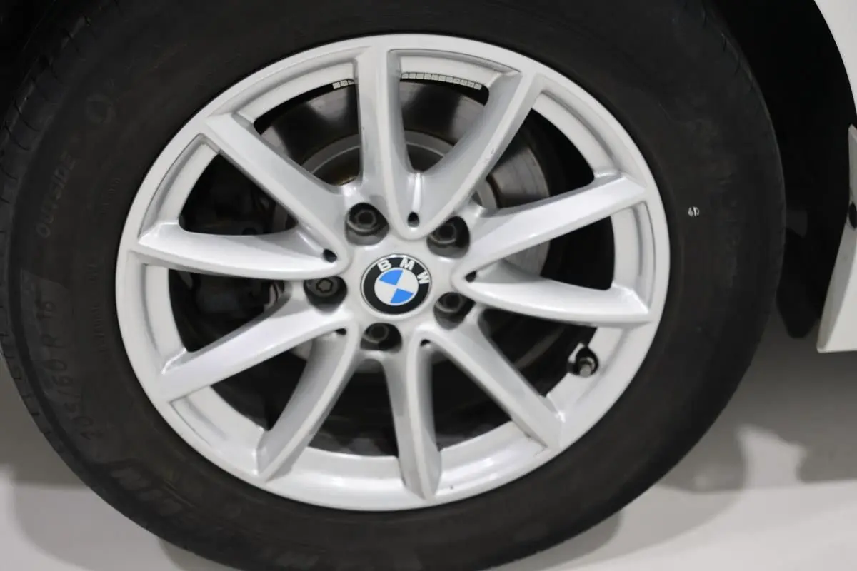 Gros plan sur la jante alliage argentée d'une BMW Série 2 Active Tourer blanche, avec logo BMW au centre.