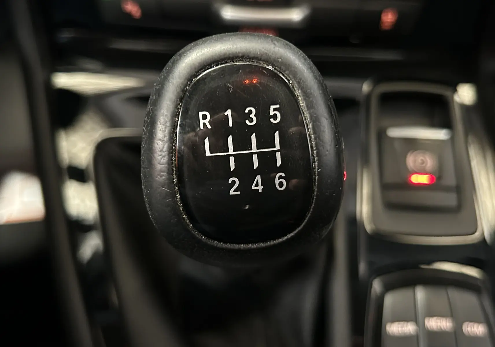 Gros plan sur le levier de vitesses manuel noir de la BMW Série 2 Active Tourer 216d, avec indication des six rapports et marche arrière.