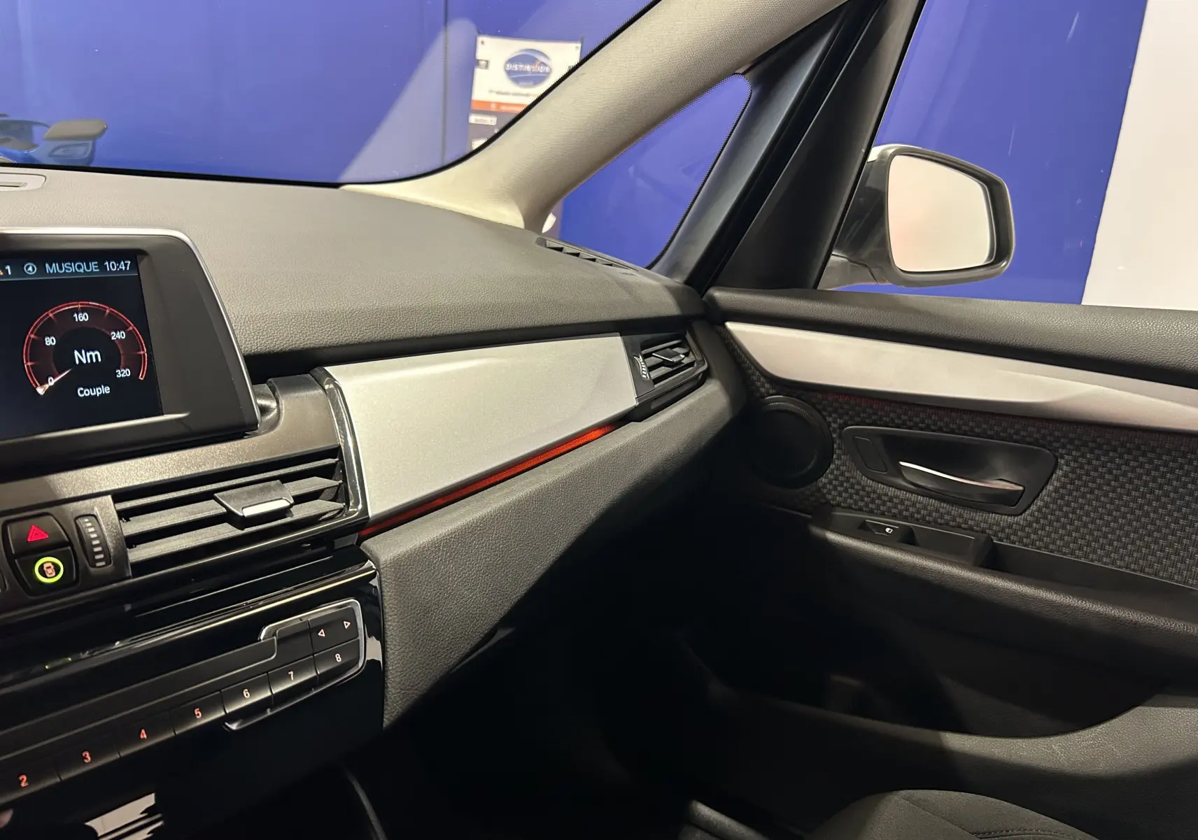 Vue intérieure côté passager de la BMW Série 2 Active Tourer 216d 2021, avec tableau de bord et garnitures noires et argentées.