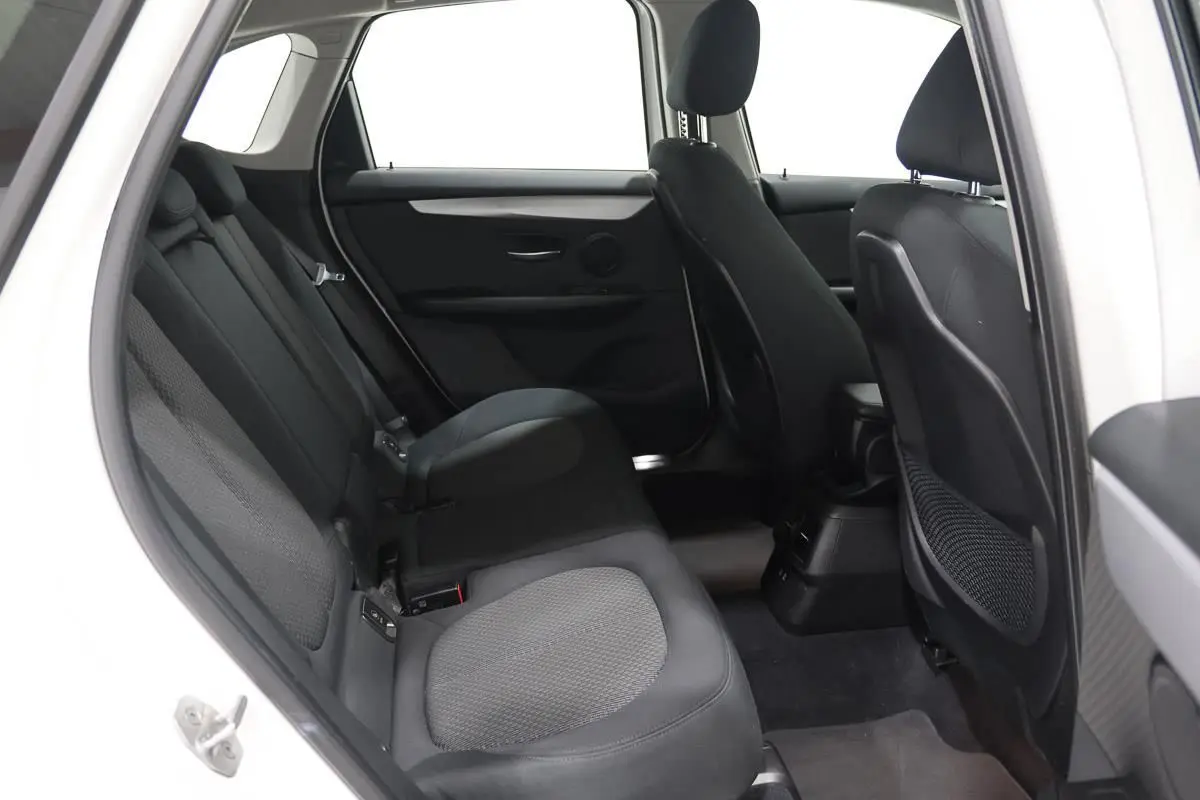 Vue intérieure côté gauche des sièges arrière noirs en tissu d'une BMW Série 2 Active Tourer blanche, version 216d.