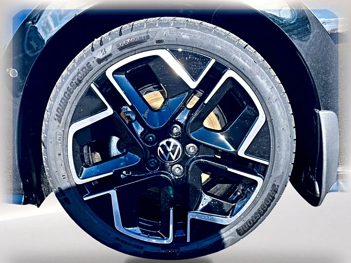 Gros plan sur la roue avant droite noire avec jante alliage noir et argentée de la Volkswagen Golf 2026.