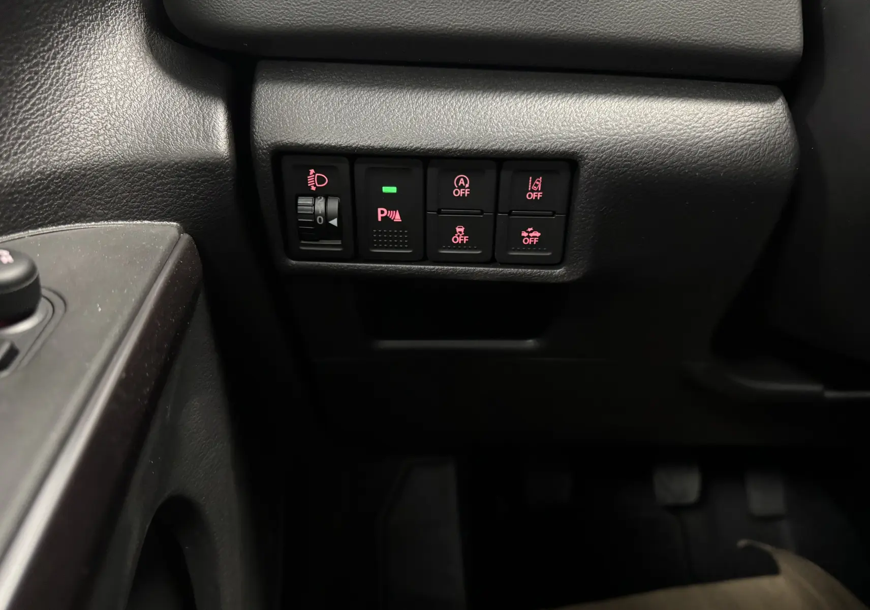 Gros plan sur les commandes de sécurité et assistance du tableau de bord du Suzuki S-Cross gris 2025 côté conducteur.