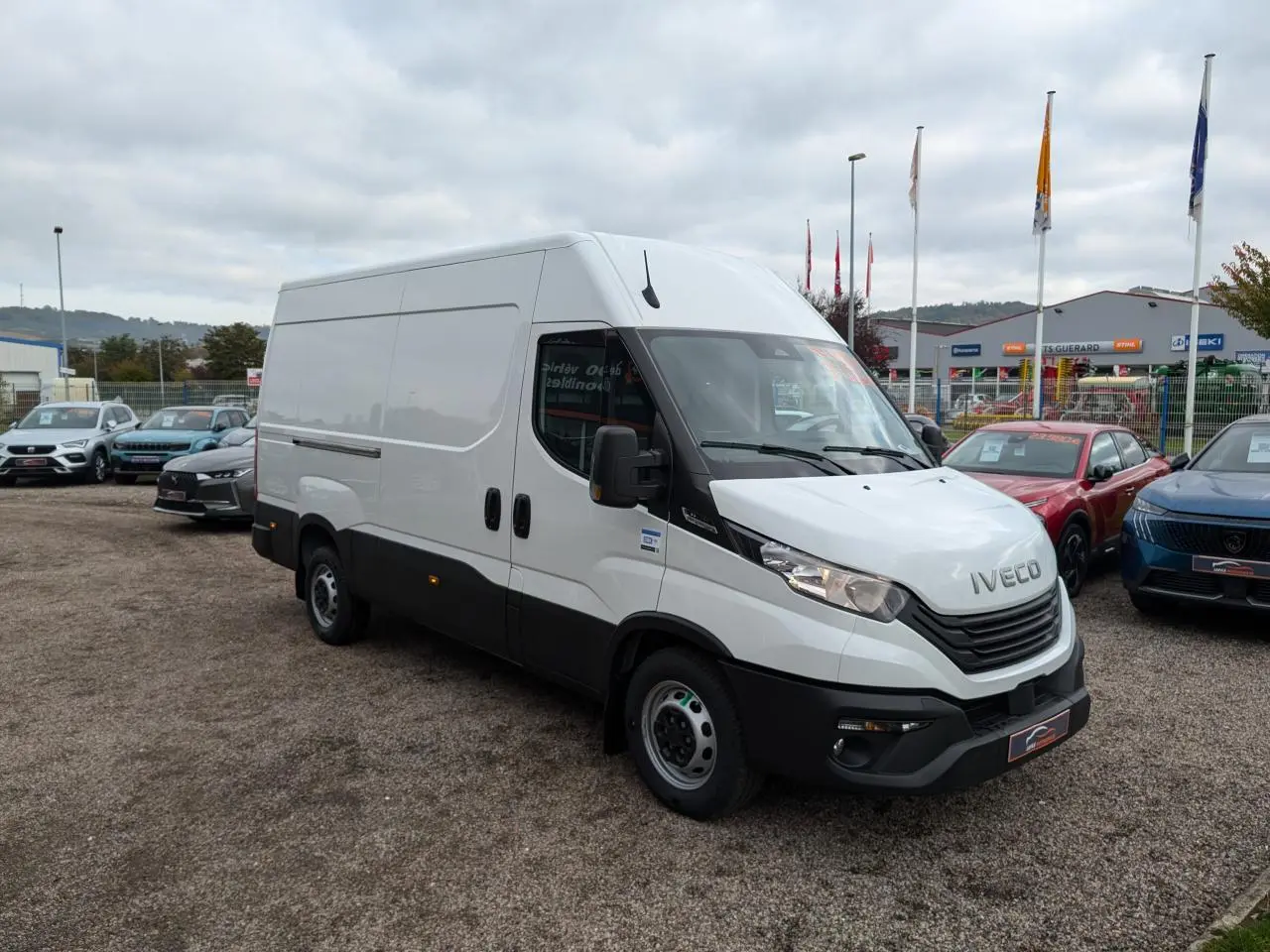 Fourgon Iveco Daily blanc vu en 3/4 avant droit avec calandre noire et portes latérales coulissantes.