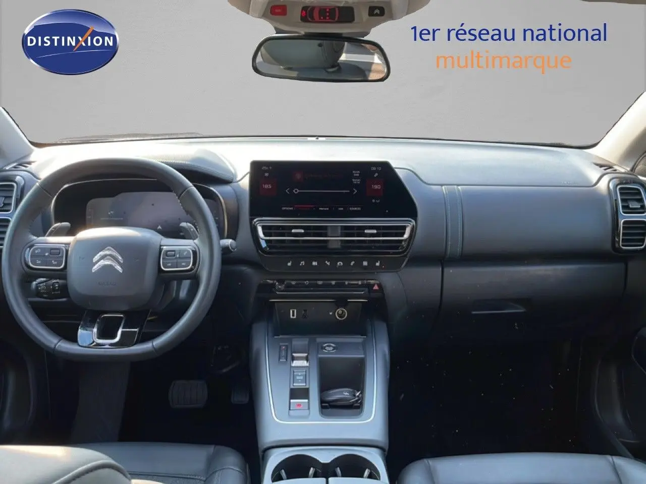 Vue intérieure avant du tableau de bord et volant du Citroën C5 Aircross bleu Eclipse Metal, avec écran tactile central et commandes modernes.
