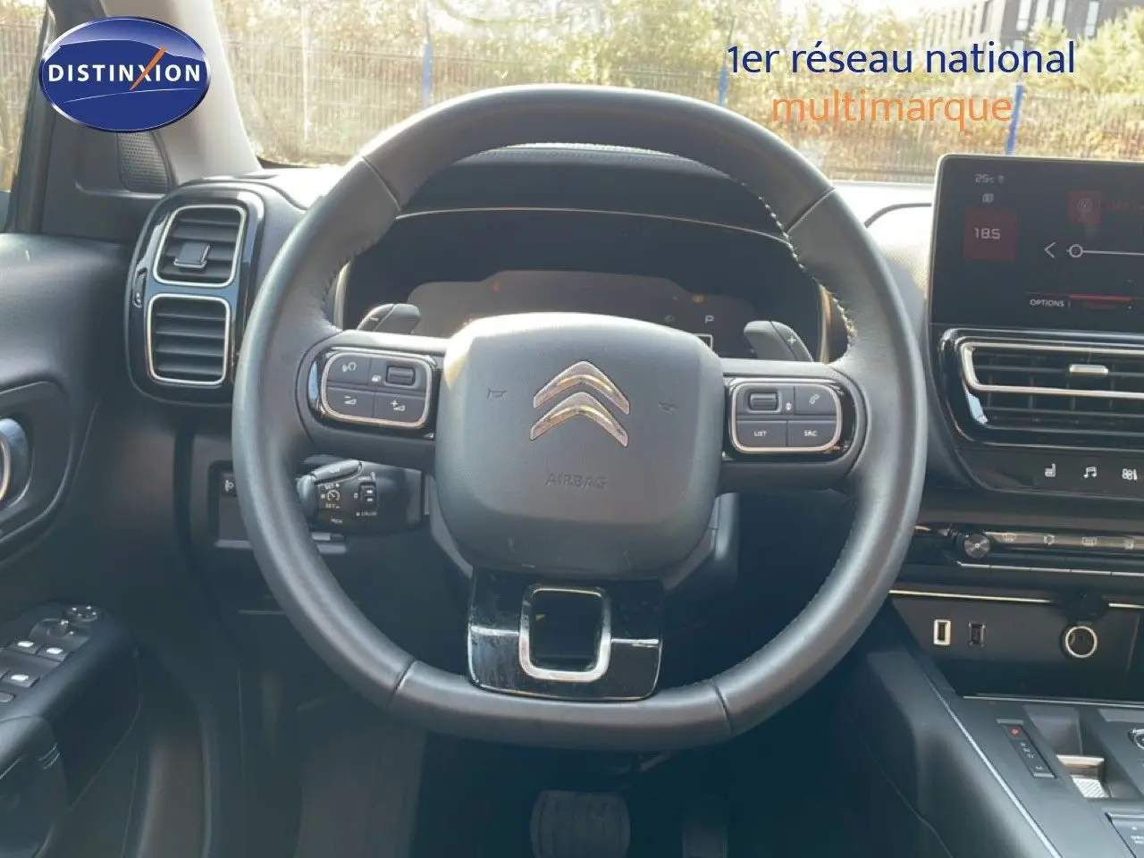 Vue intérieure centrée sur le volant noir du Citroën C5 Aircross 2025, avec tableau de bord et écran tactile visibles.