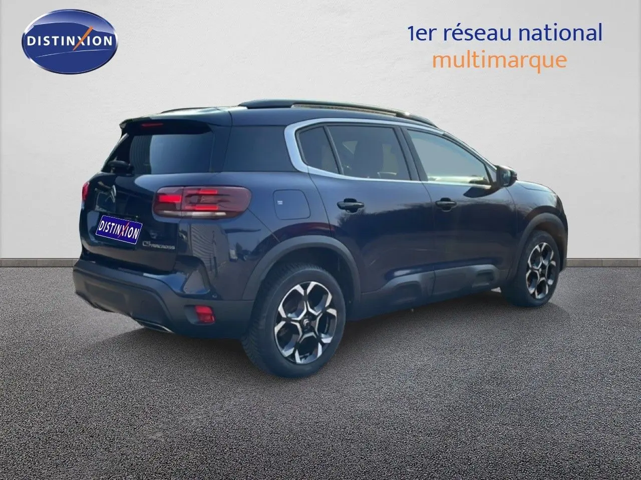 Vue 3/4 arrière droite d’un Citroën C5 Aircross bleu Eclipse Métal avec jantes bi-ton et toit noir.