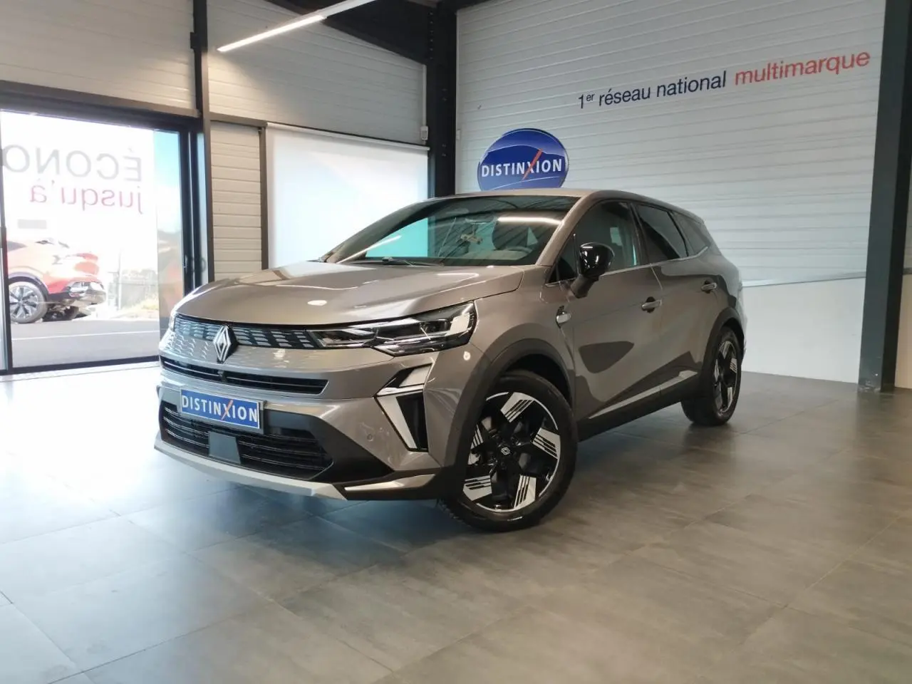 Renault Symbioz gris Cassiopée en 3/4 avant droit, avec jantes 18 pouces et calandre au design moderne.