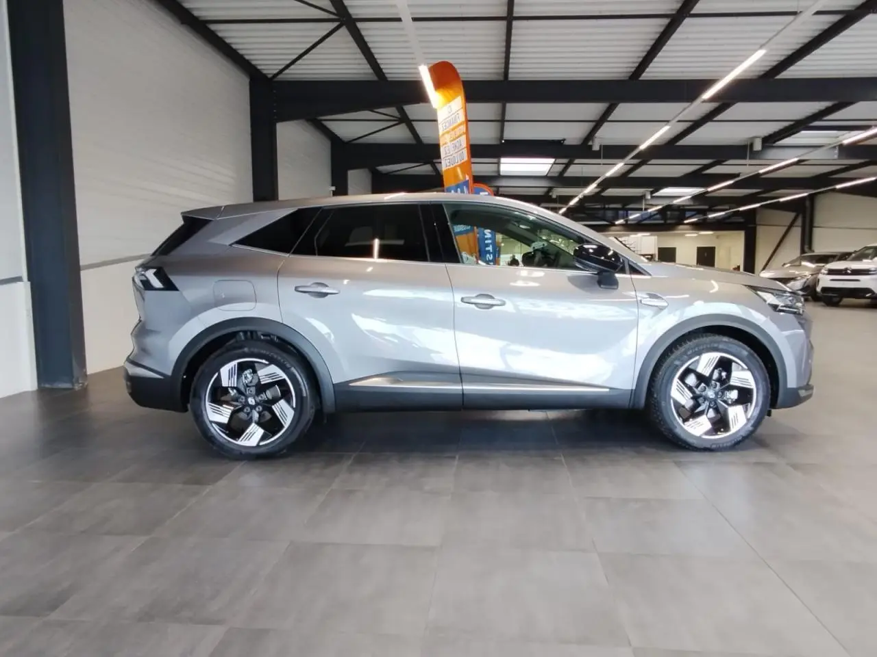 Renault Symbioz 2025 gris Cassiopée vue de profil côté gauche avec jantes alliage 19 pouces Pulsar.