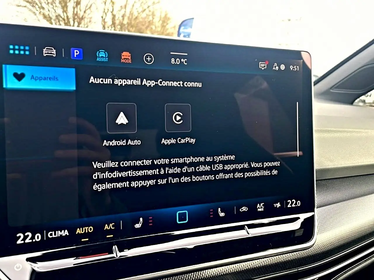 Écran tactile central affichant la connectivité smartphone dans l'habitacle clair d'une Volkswagen Golf noire.