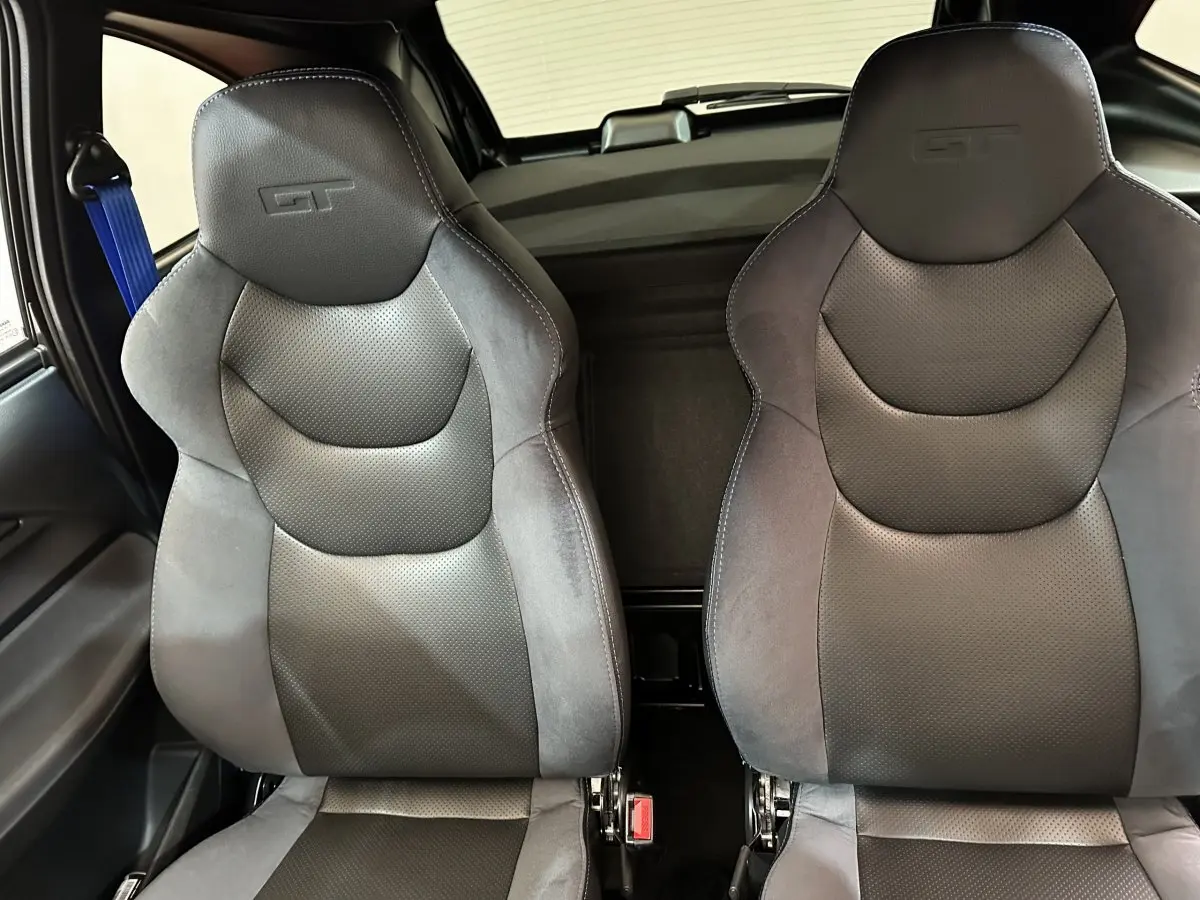 Vue intérieure rapprochée des sièges avant noirs GT de l'AIXAM AMBITION 0.5 CITY COUPE GTI E5+ 2026.