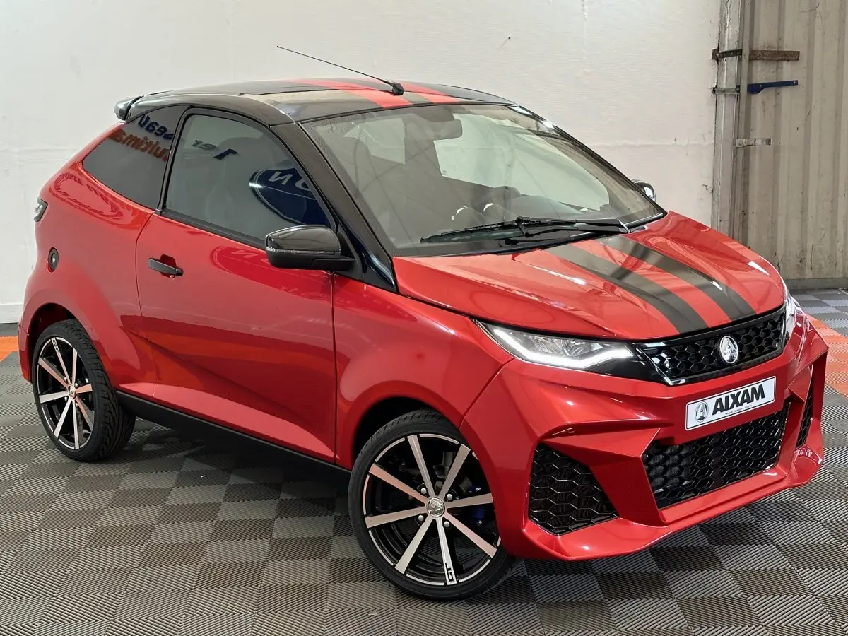 Vue 3/4 avant droite de l'AIXAM AMBITION 0.5 CITY COUPE GTI rouge avec bandes noires et jantes alliage.
