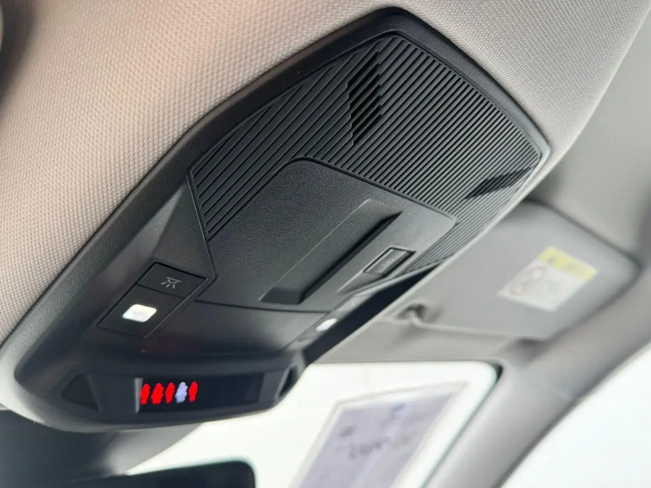 Vue en gros plan du plafonnier noir et beige avec éclairage intérieur de la Peugeot 308 SW blanche 2024