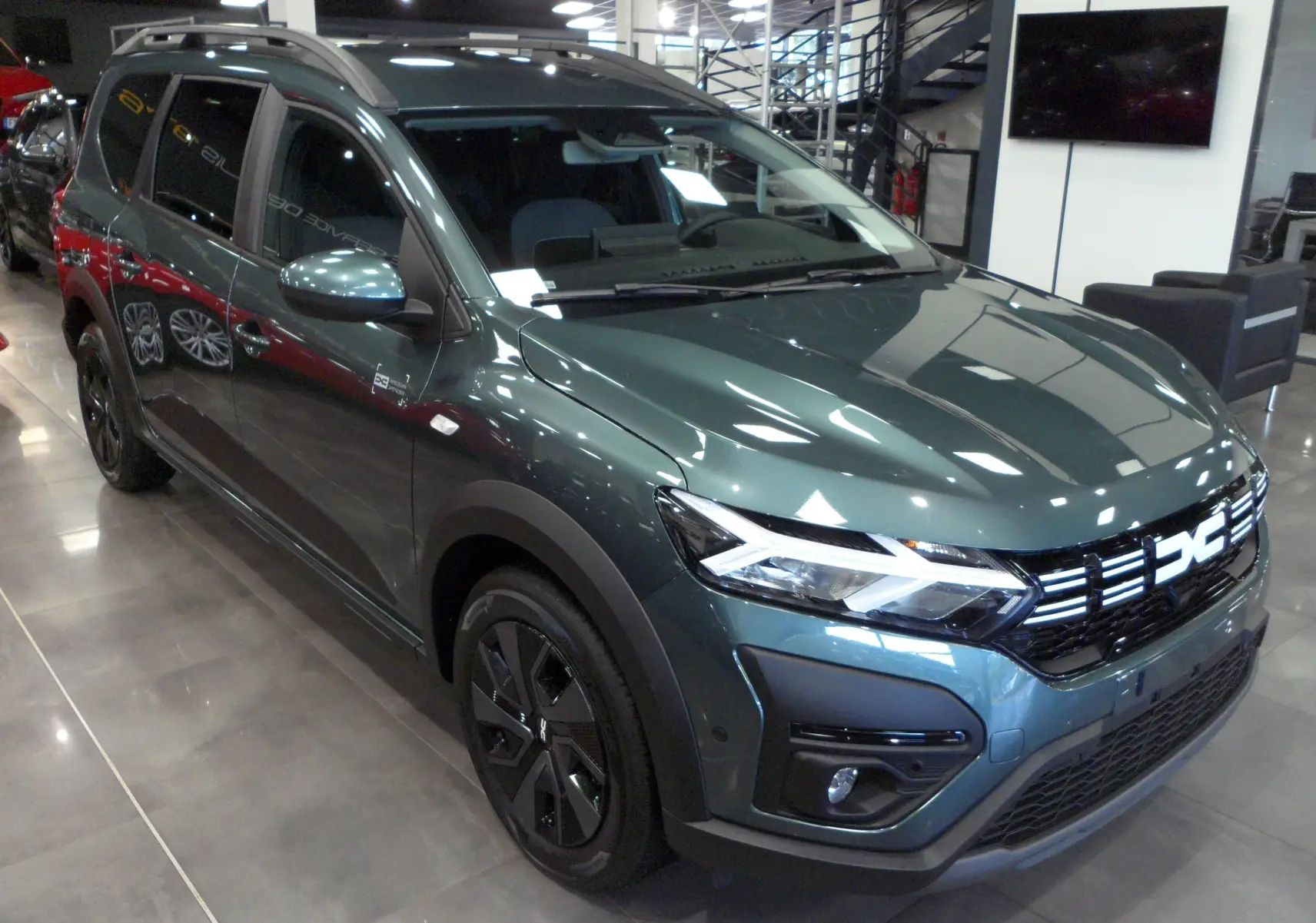 Dacia Jogger TCe 110 Vert Cèdre en 3/4 avant droit, avec calandre distinctive et jantes noires.