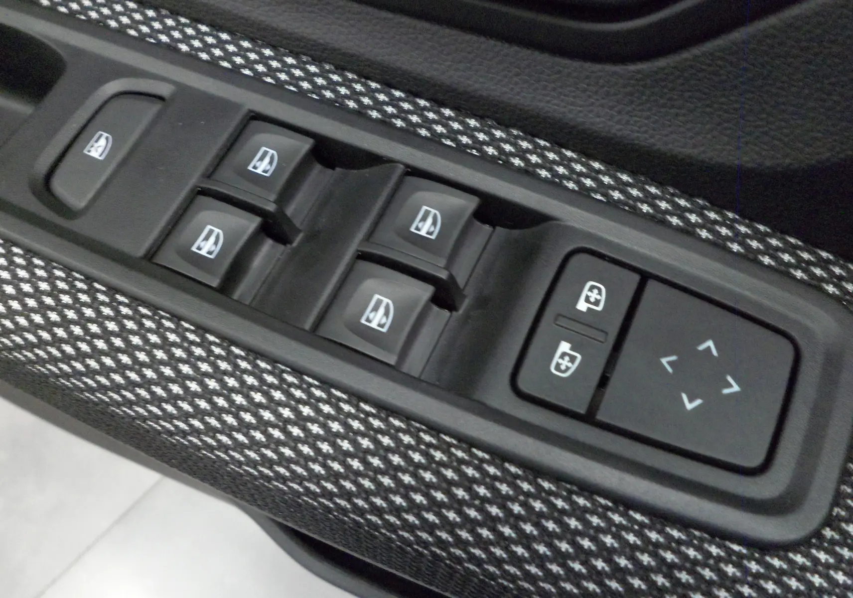 Gros plan sur les commandes de lève-vitres et réglage des rétroviseurs du Dacia Jogger TCe 110 CH Expression 7 places.