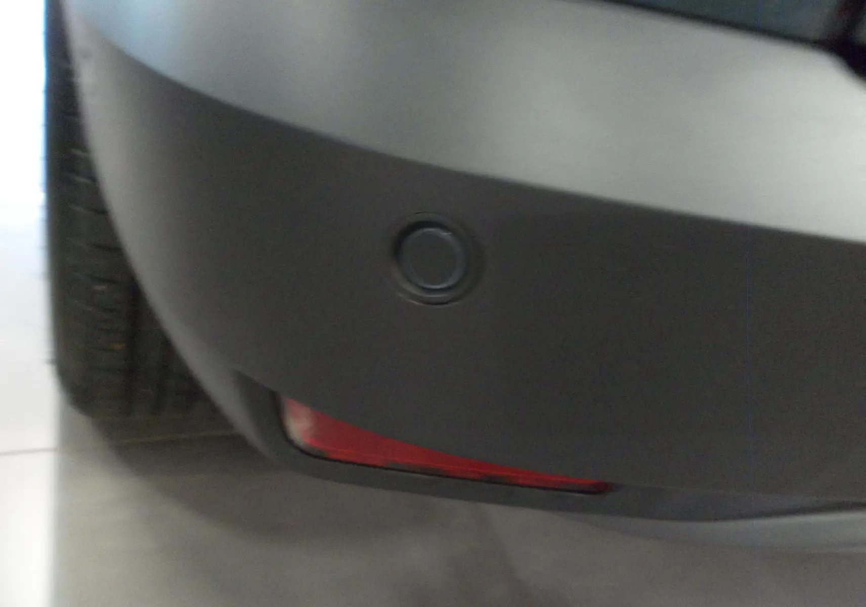 Gros plan sur le pare-chocs arrière gris foncé du Dacia Jogger 2025, avec feu antibrouillard rouge intégré.