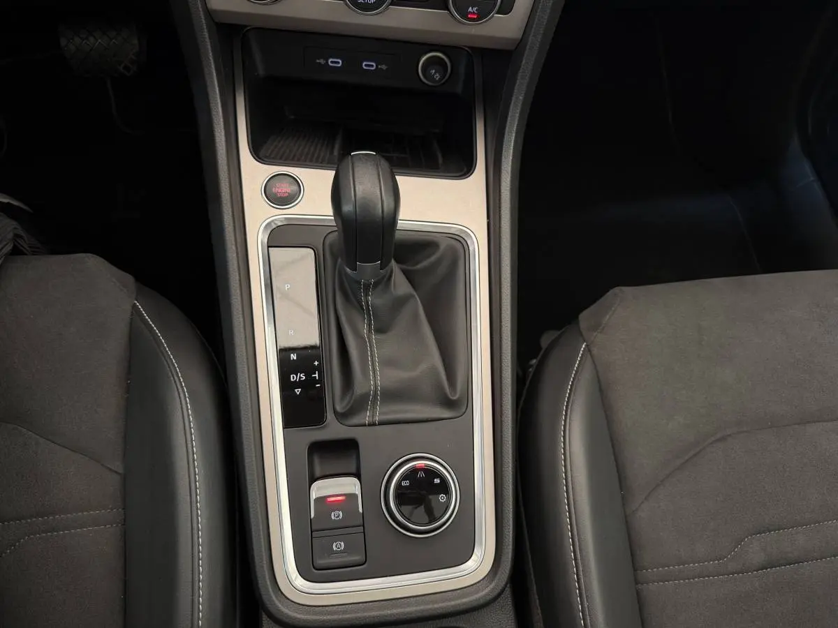 Vue plongeante sur la console centrale du SEAT Ateca gris clair, avec levier de vitesses automatique et commandes de conduite.