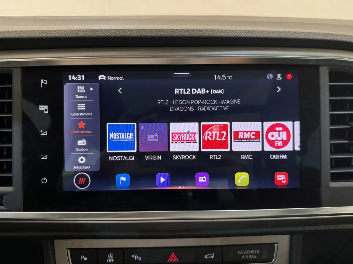Écran tactile central affichant les stations radio dans l'habitacle d'un SEAT Ateca gris clair 2023.