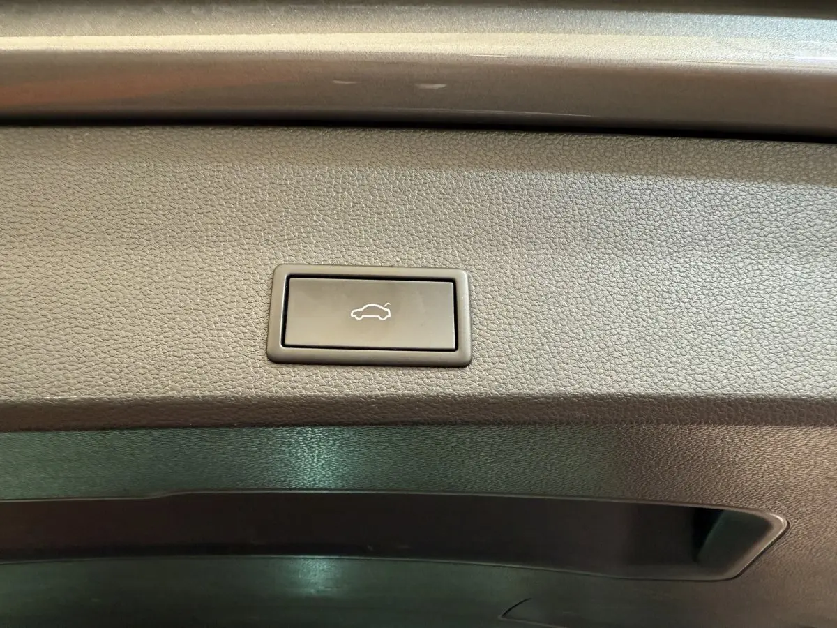 Bouton d'ouverture électrique du coffre sur la garniture intérieure gris clair du SEAT Ateca 2023.