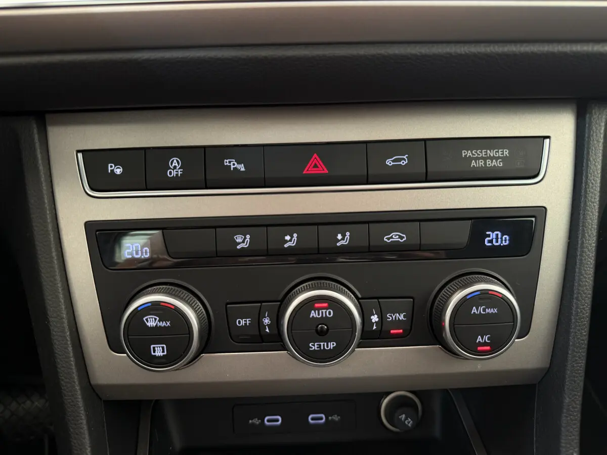 Vue rapprochée du panneau de commande de climatisation gris clair du SEAT Ateca 2023 avec affichage digital et boutons rotatifs.