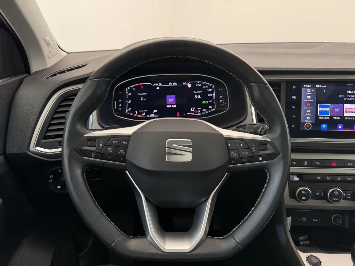 Vue intérieure centrée sur le volant cuir noir et l'instrumentation digitale du SEAT Ateca 2023.