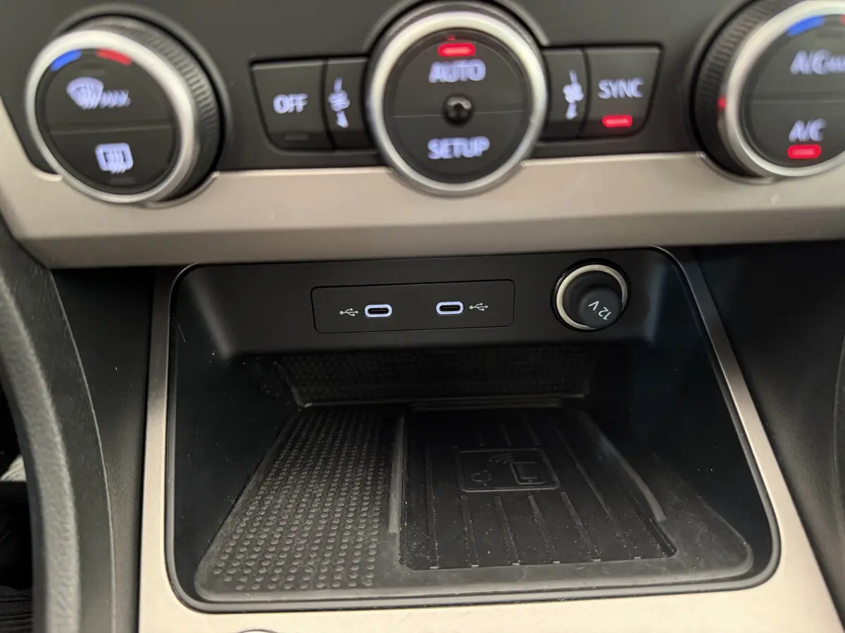 Gros plan sur la console centrale du SEAT Ateca 2023, zone de recharge sans fil et ports USB-C visibles.