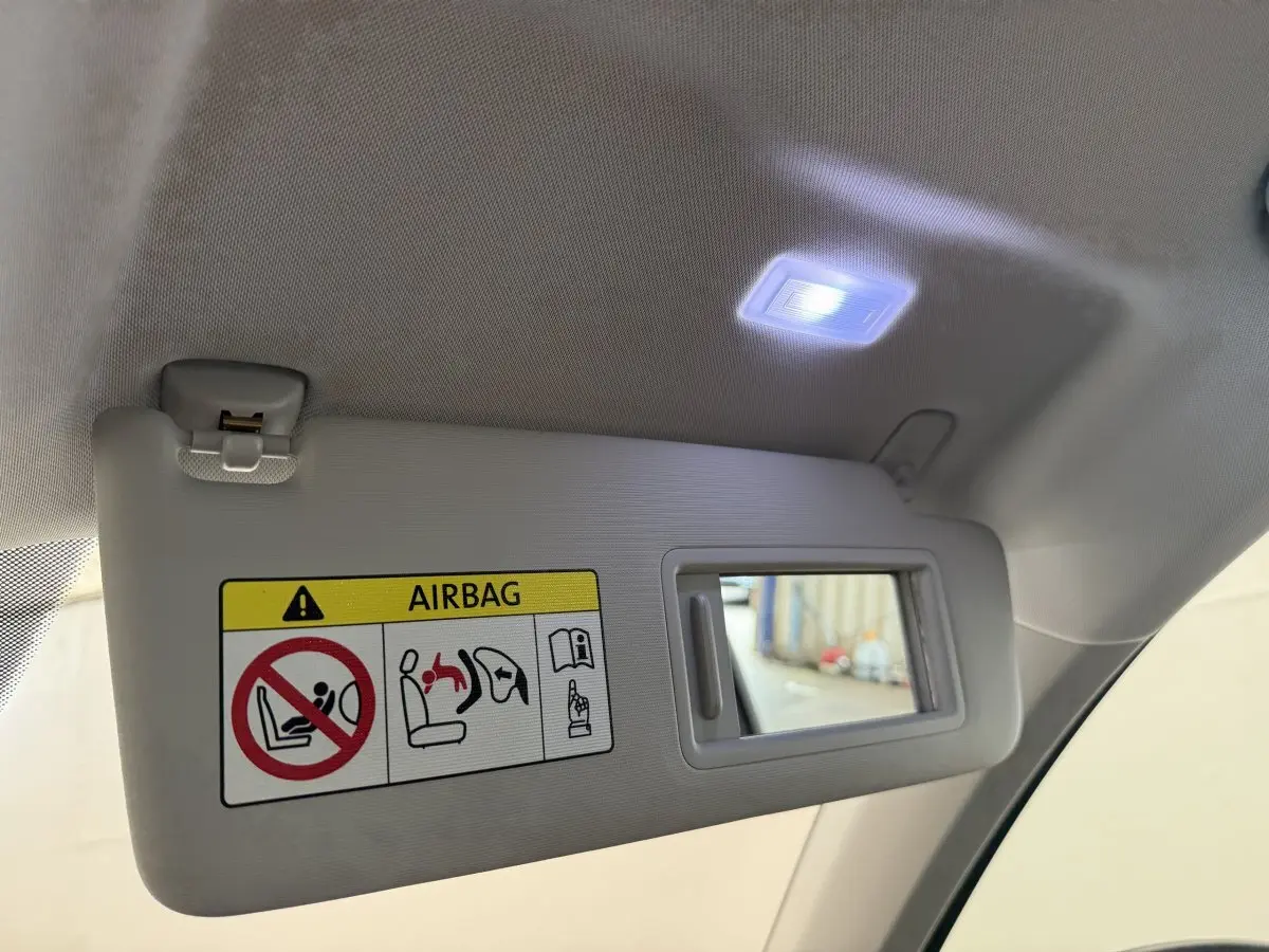 Détail du pare-soleil intérieur gris clair du SEAT Ateca 2023 avec miroir éclairé et avertissement airbag visible.