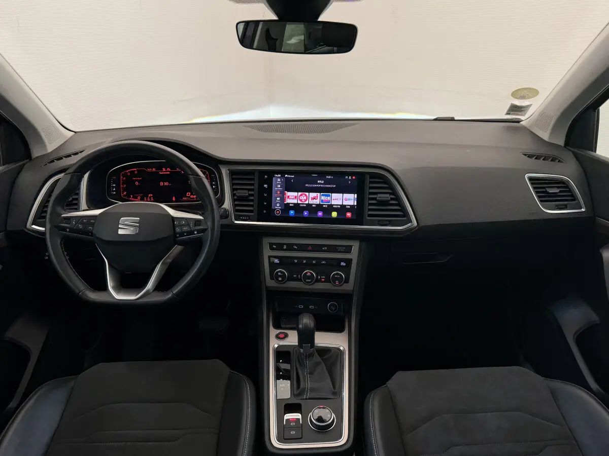 Intérieur noir du SEAT Ateca 2023, vue frontale du tableau de bord avec écran tactile central et volant multifonction.