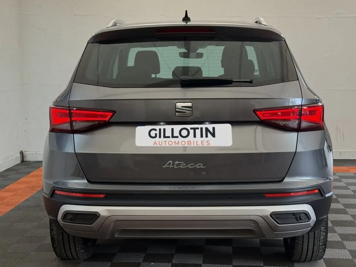 Vue arrière d'un SUV SEAT Ateca gris clair avec feux LED et double sortie d'échappement intégrée au pare-chocs.