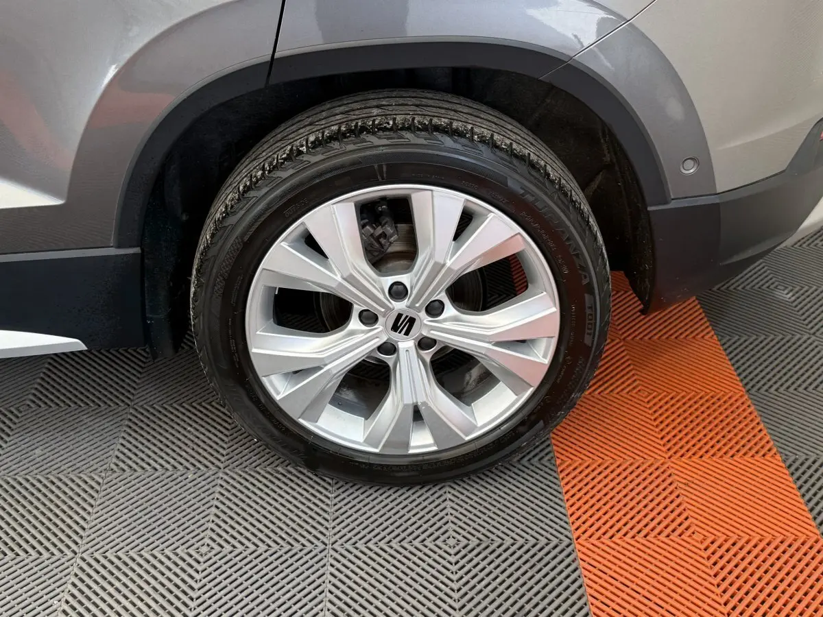 Gros plan sur la roue avant gauche gris clair du SEAT Ateca 2023 avec jante alliage et logo central noir.