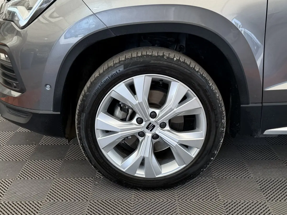 Gros plan sur la roue avant gauche gris clair du SEAT Ateca 2023 avec jante alliage et logo central visible.