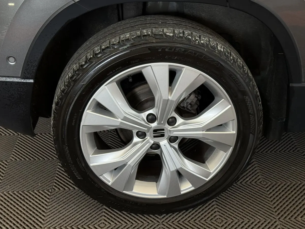 Gros plan sur la roue avant droite gris clair du SEAT Ateca 2023 avec jante alliage à 5 branches doubles.