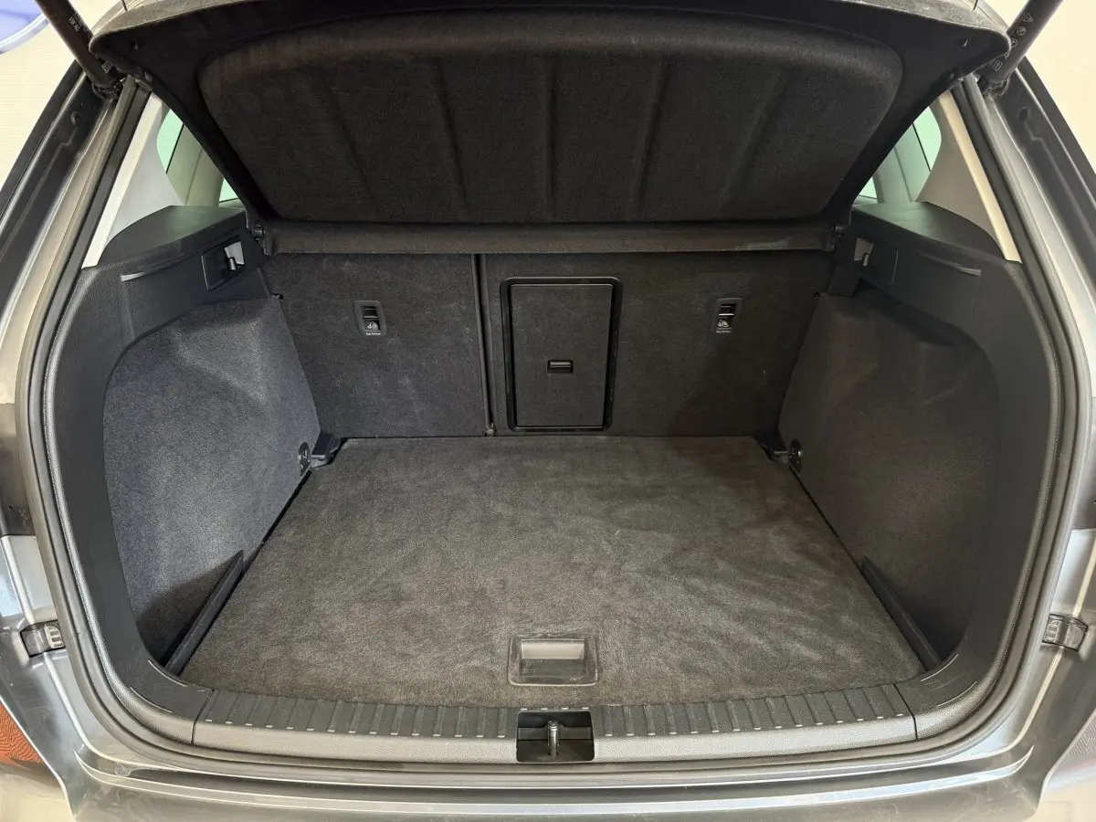 Coffre ouvert gris clair du SEAT Ateca 2023, vue intérieure montrant l'espace de chargement et la trappe centrale.