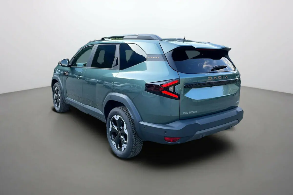 SUV Dacia Bigster vert cèdre vu en 3/4 arrière droit, avec feux arrière en forme de flèche et toit noir.