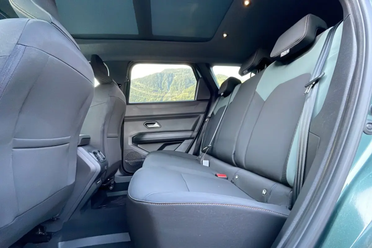 Vue intérieure arrière côté droit du Dacia Bigster 2025 vert cèdre, montrant les sièges arrière et la porte ouverte.