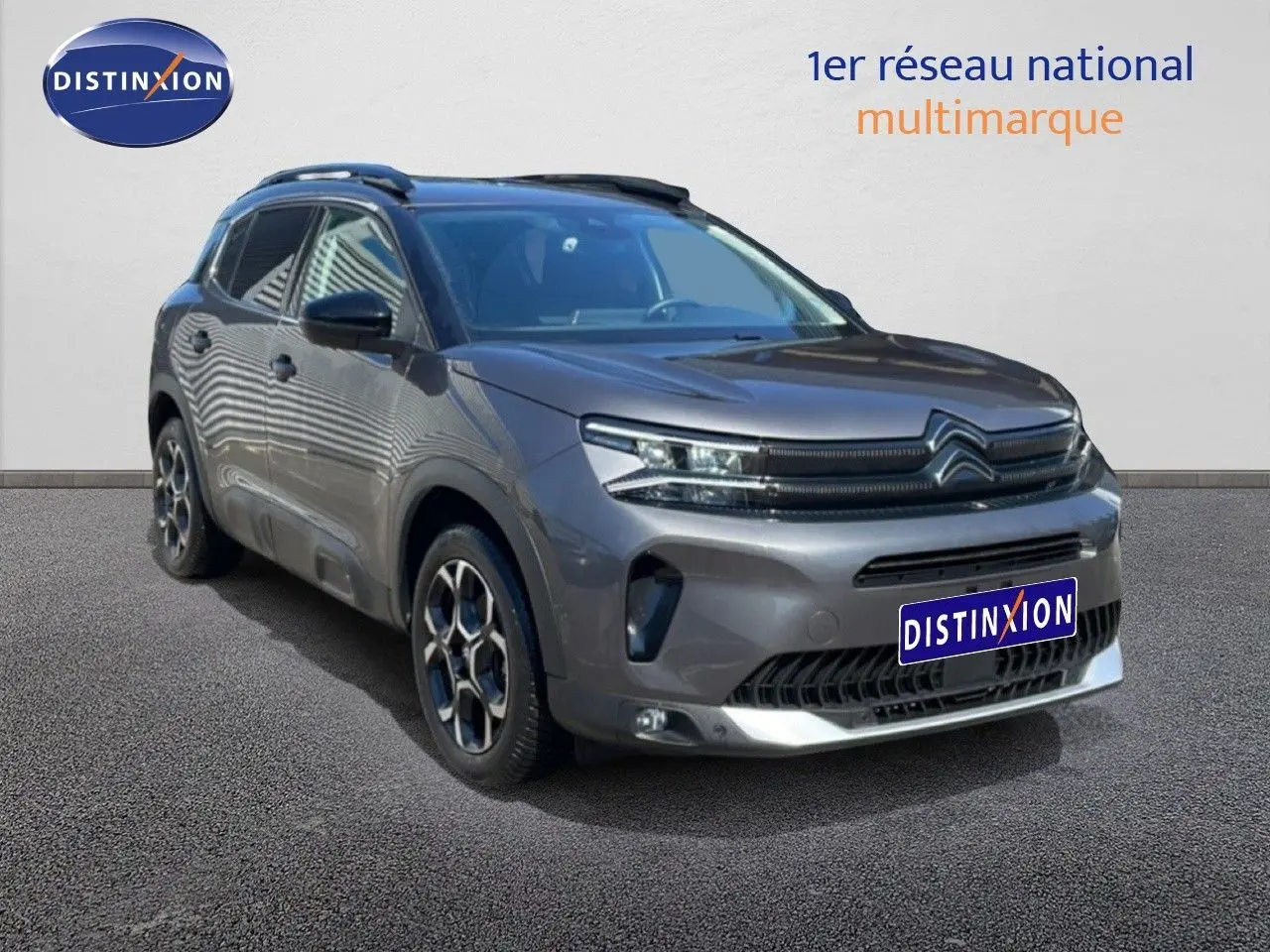 Citroën C5 Aircross gris platinium métal en 3/4 avant droit, avec jantes bi-ton et calandre distinctive.