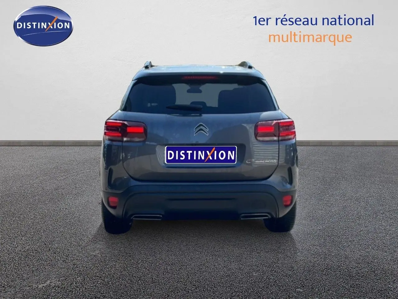Vue arrière d'un Citroën C5 Aircross gris platinium métal 2025 avec feux arrière LED et double sortie d'échappement intégrée.