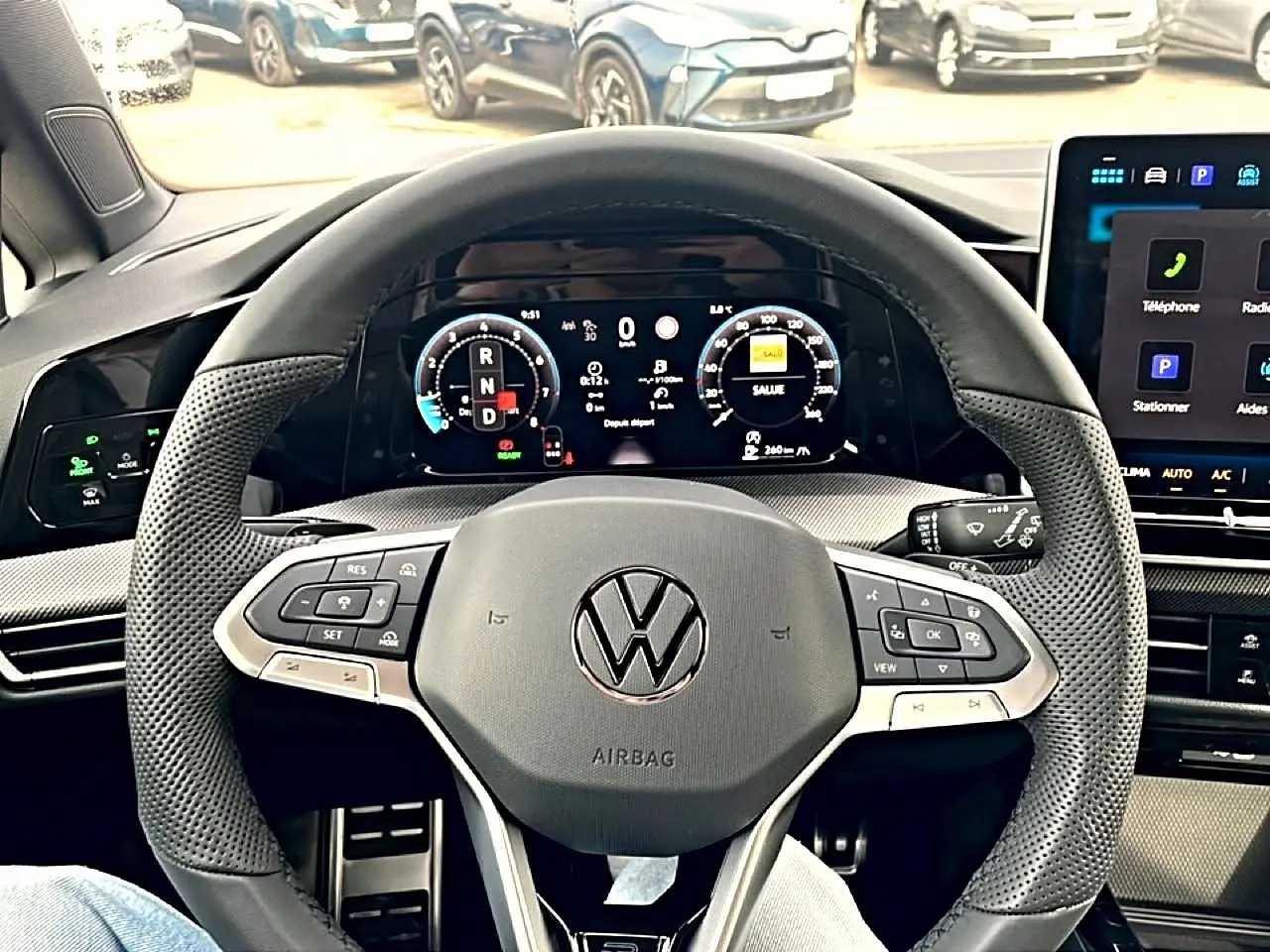 Vue intérieure centrée sur le volant sport noir perforé de la Volkswagen Golf 1.5 ETSI Evo2 2026 avec tableau de bord numérique.