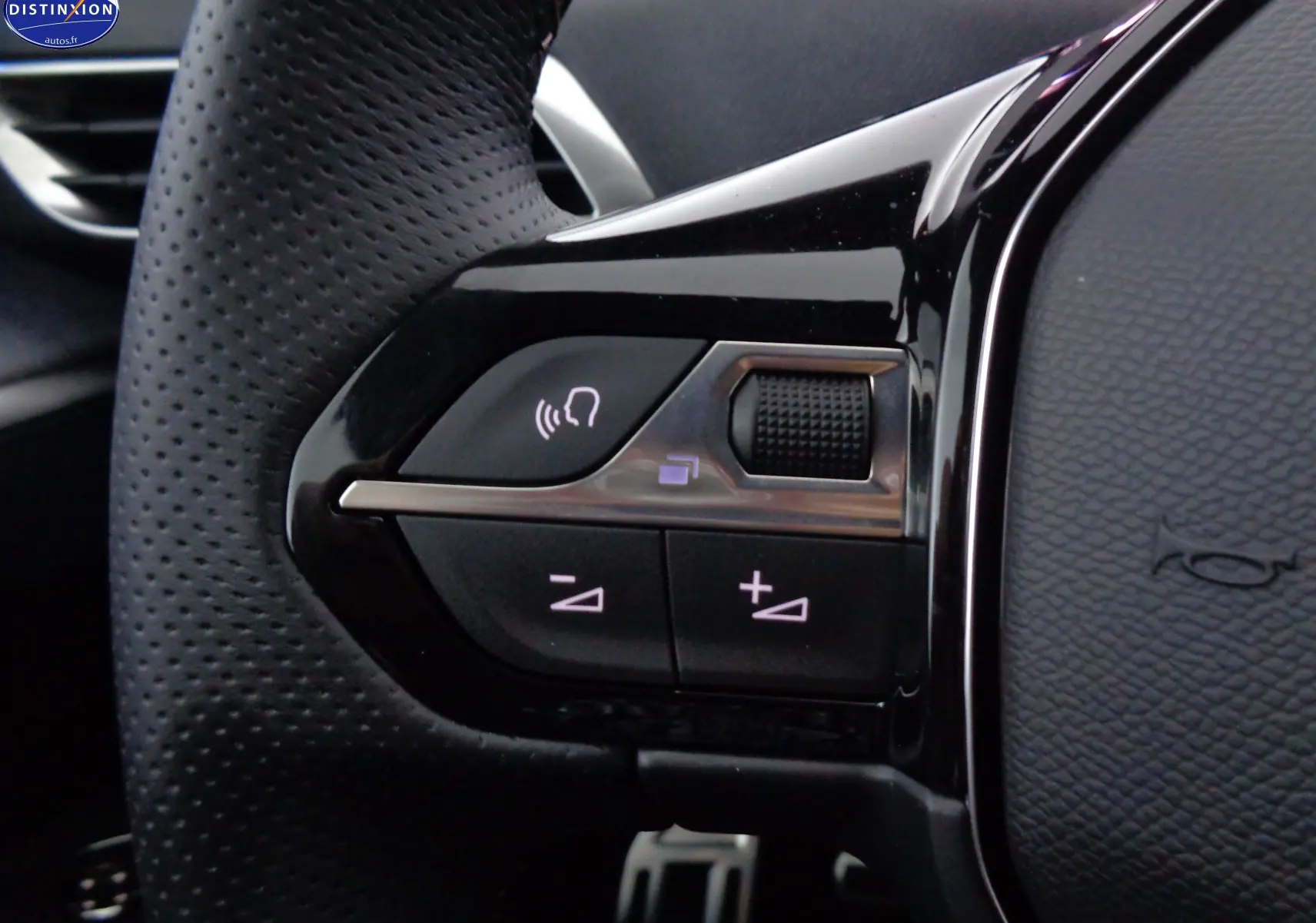 Gros plan sur les commandes gauche du volant perforé d’un Peugeot 3008 GT 2023 noir Perla Nera Metal.