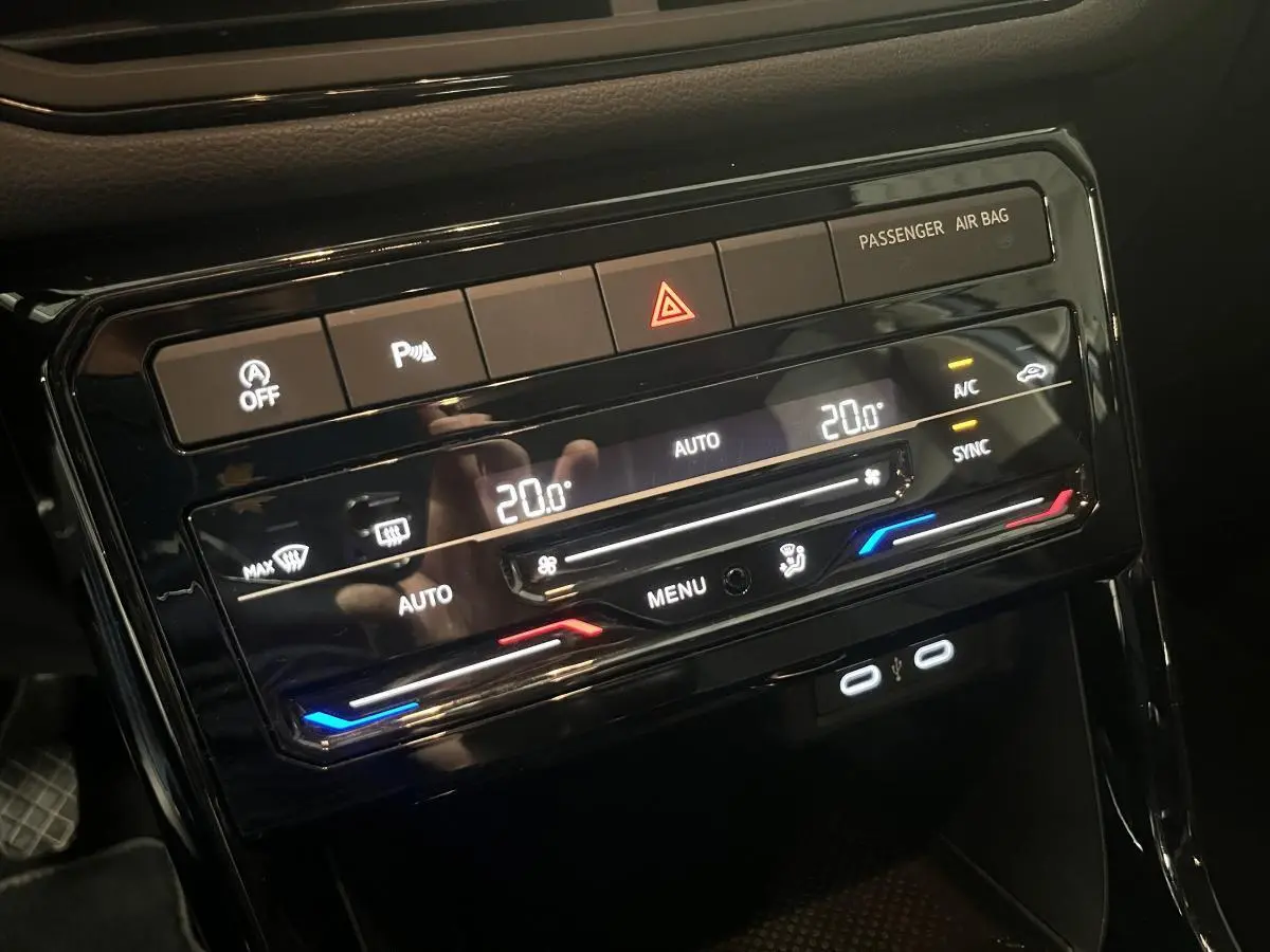 Vue rapprochée de la console centrale du Volkswagen T-Cross 2024, affichant la climatisation automatique à 20°C et ports USB-C.