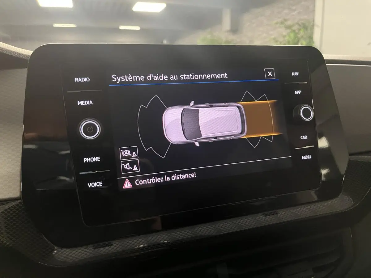 Écran tactile du système d'aide au stationnement du Volkswagen T-Cross 2024 affichant une vue du dessus du véhicule.