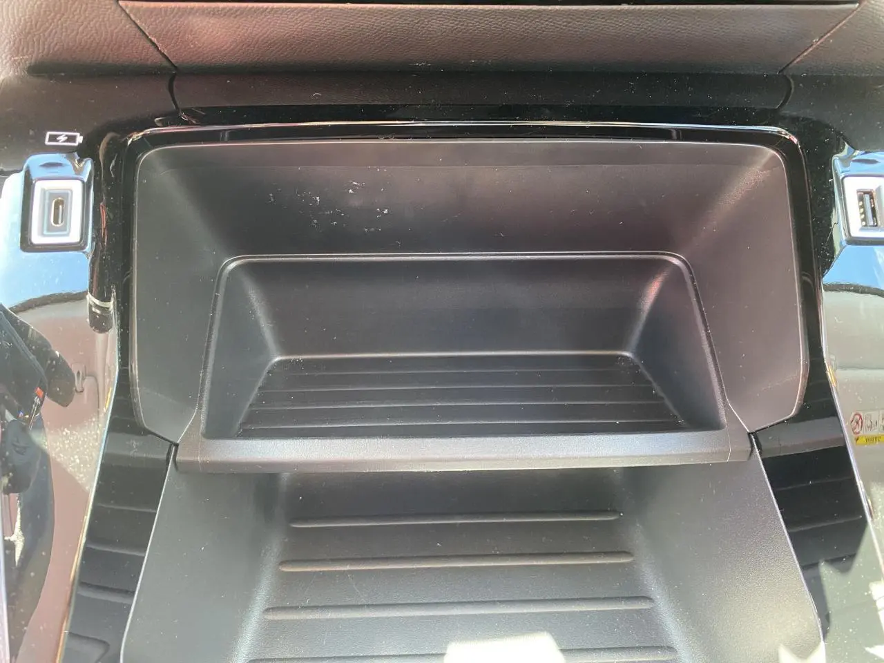 Rangement central noir avec ports USB et prise 12V dans l'habitacle d'un Peugeot 2008 bleu 2021 Active Pack.