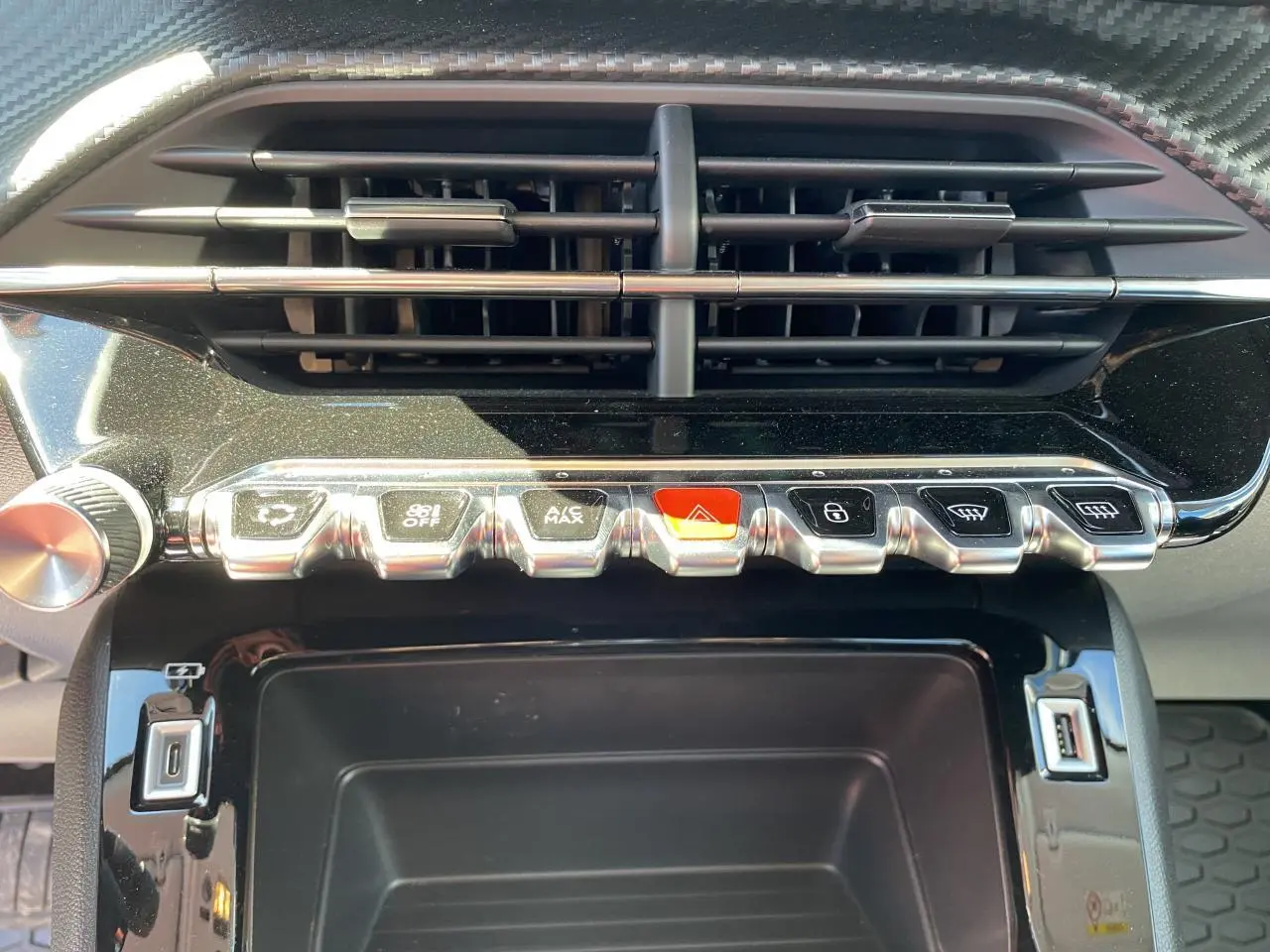 Gros plan sur la console centrale du Peugeot 2008 bleu 2021, montrant les commandes climatisation et prises USB.